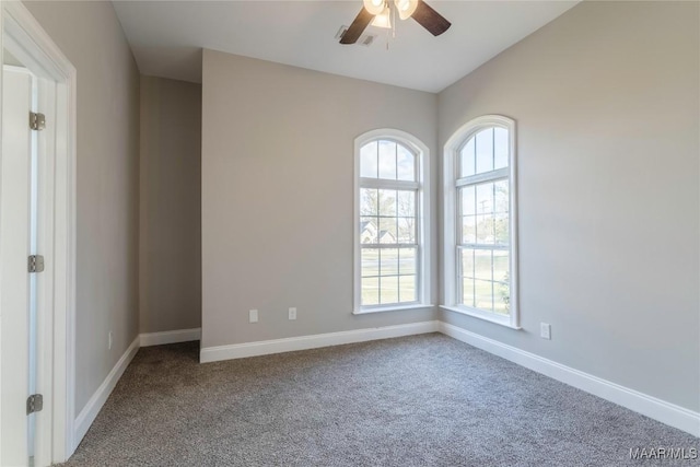 carpeted spare room featuring a ceiling fan, a wealth of natural light, and baseboards