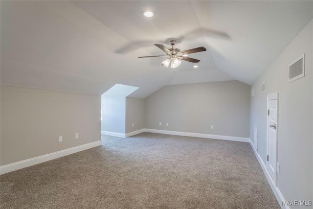 additional living space featuring lofted ceiling, baseboards, visible vents, and carpet flooring