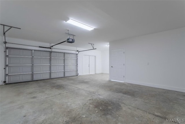 garage featuring a garage door opener and baseboards