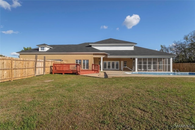 back of house with a fenced in pool, french doors, a sunroom, a fenced backyard, and a wooden deck