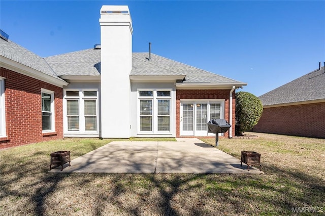 back of house featuring an outdoor fire pit, a patio area, brick siding, and a chimney