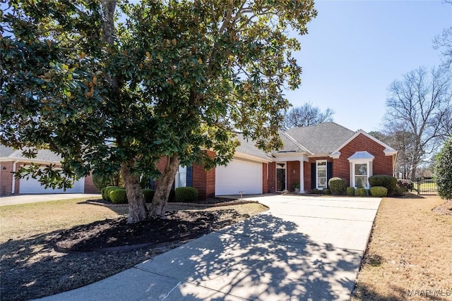 view of front of home featuring a garage, brick siding, driveway, and fence