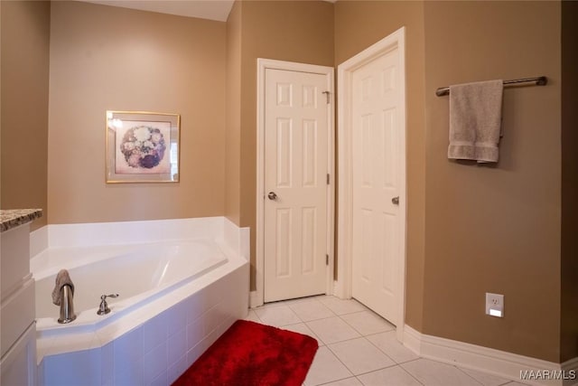 full bath with baseboards, a garden tub, and tile patterned floors