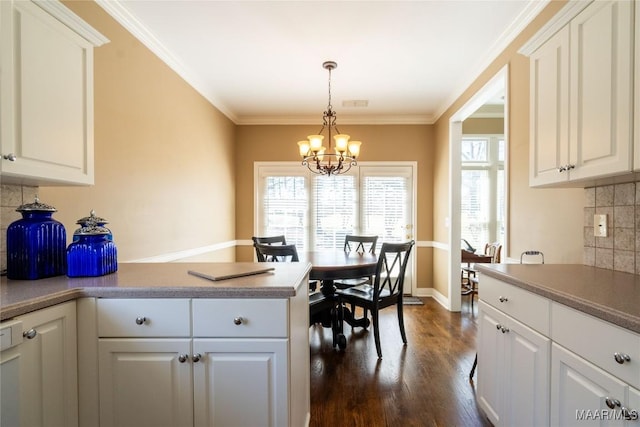 kitchen featuring a chandelier, a peninsula, dark wood-style floors, and a wealth of natural light