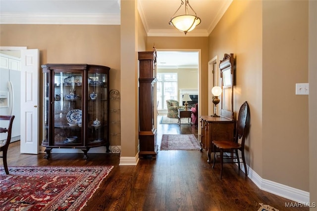foyer entrance with ornamental molding, dark wood-type flooring, and baseboards