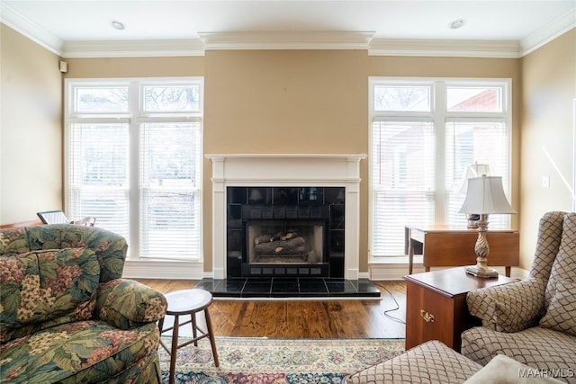 living area with plenty of natural light, ornamental molding, and wood finished floors