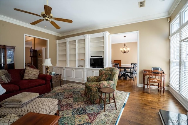 living area featuring dark wood-style flooring, crown molding, visible vents, baseboards, and ceiling fan with notable chandelier