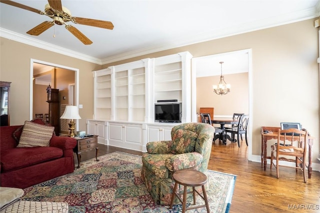 living room with ceiling fan with notable chandelier, light wood-type flooring, baseboards, and crown molding