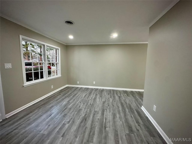 spare room featuring dark wood finished floors, recessed lighting, visible vents, ornamental molding, and baseboards