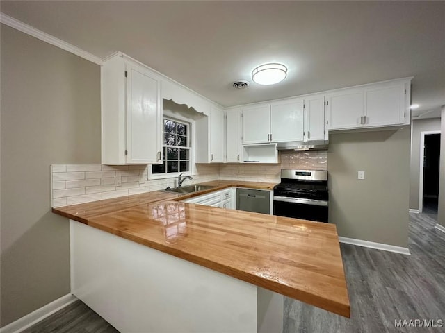 kitchen with stainless steel appliances, visible vents, a peninsula, butcher block countertops, and under cabinet range hood