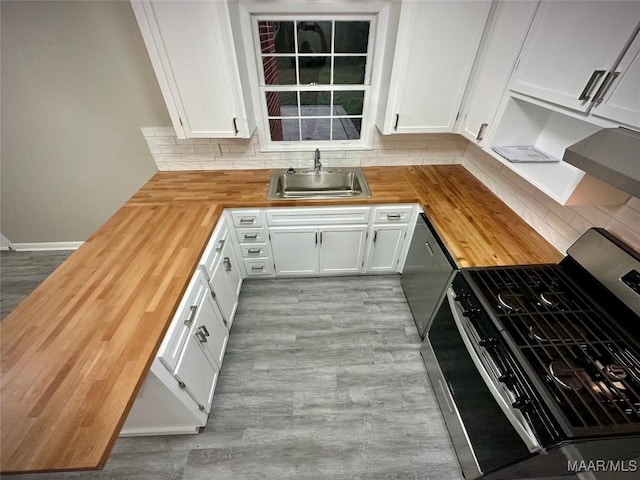 kitchen featuring wood counters, wood finished floors, a sink, stainless steel appliances, and backsplash