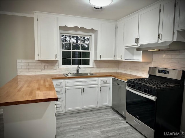 kitchen featuring visible vents, appliances with stainless steel finishes, a sink, wood counters, and under cabinet range hood