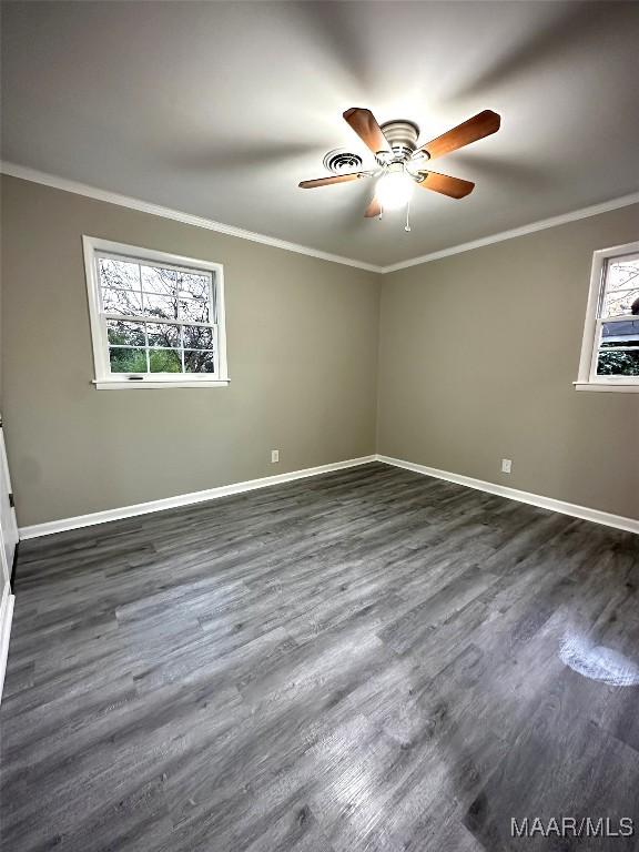 unfurnished bedroom featuring ornamental molding, dark wood finished floors, and baseboards