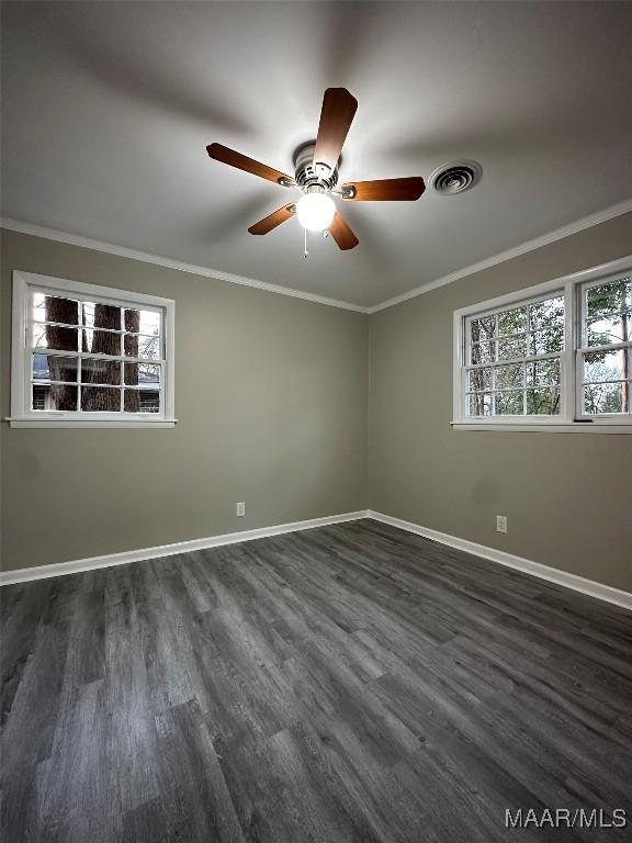 spare room featuring ornamental molding, visible vents, and baseboards