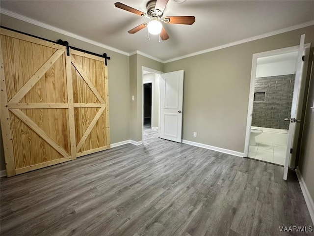 unfurnished bedroom with baseboards, wood finished floors, and crown molding