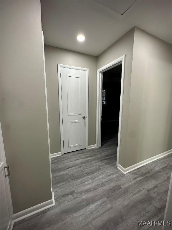 corridor featuring baseboards, wood finished floors, and recessed lighting