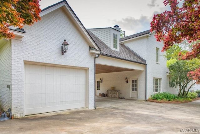 view of front of property with driveway, brick siding, and an attached garage