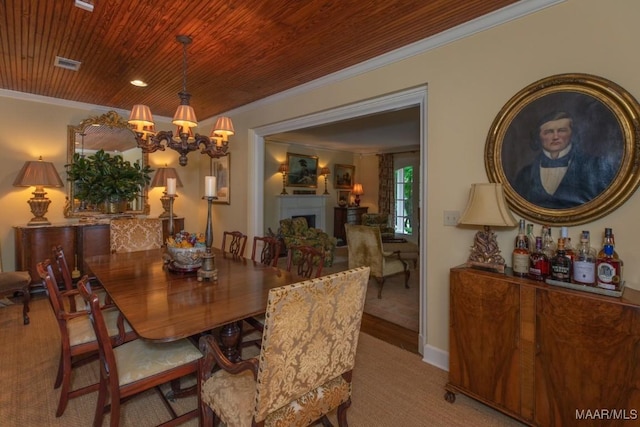 dining space featuring visible vents, wooden ceiling, ornamental molding, an inviting chandelier, and a fireplace