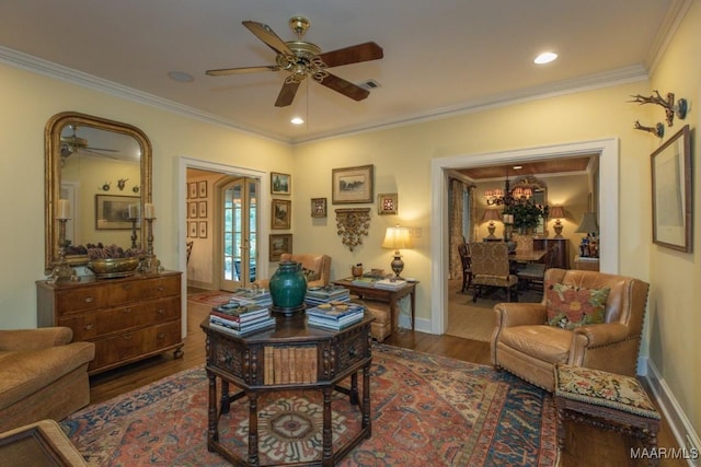 interior space with ceiling fan, baseboards, wood finished floors, and crown molding