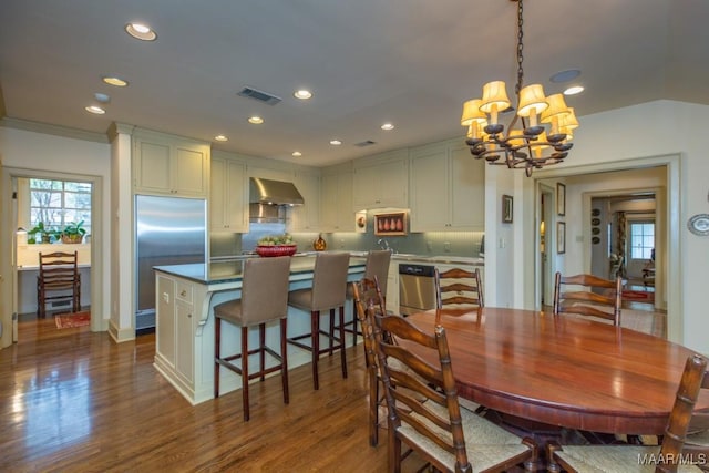 dining room featuring a notable chandelier, recessed lighting, visible vents, ornamental molding, and dark wood-style floors