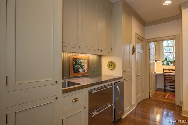 kitchen with a sink, stainless steel dishwasher, white cabinetry, and dark wood-style flooring