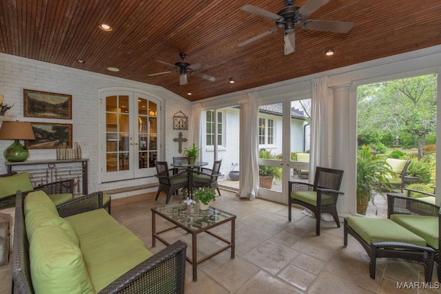 sunroom with wood ceiling, a fireplace, ceiling fan, and french doors