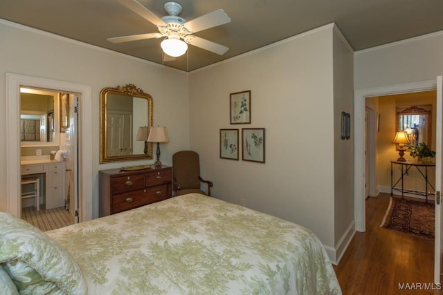 bedroom featuring crown molding, baseboards, wood finished floors, and ensuite bathroom