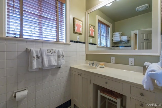 bathroom featuring a wainscoted wall, tile walls, and vanity