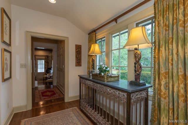 corridor with dark wood-style floors, lofted ceiling, baseboards, and recessed lighting