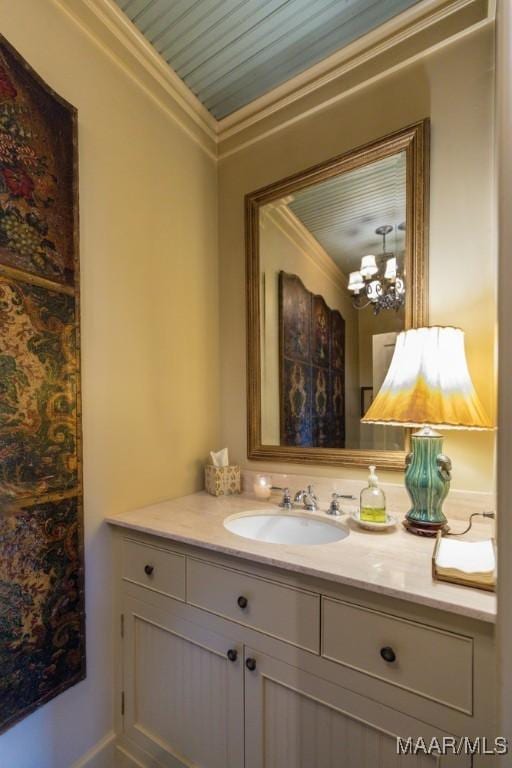 bathroom featuring ornamental molding, vanity, and an inviting chandelier