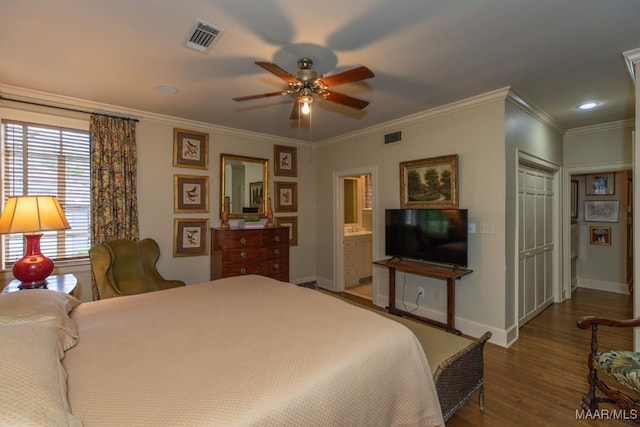 bedroom with ornamental molding, wood finished floors, visible vents, and baseboards