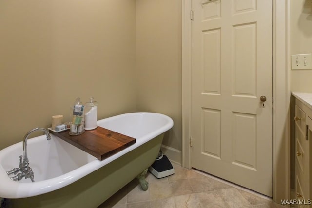 full bathroom featuring a freestanding bath, tile patterned flooring, vanity, and baseboards