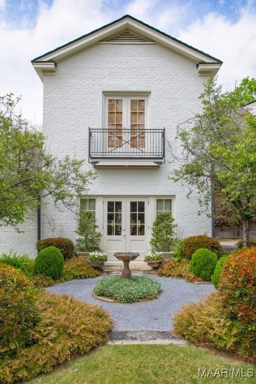 rear view of property with french doors and a balcony