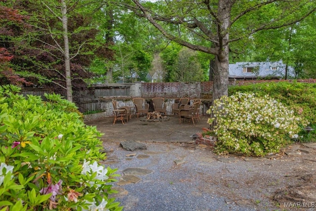 view of patio / terrace with an outdoor fire pit and fence