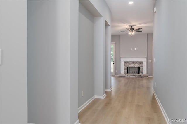 hall with light wood-style floors, baseboards, and recessed lighting