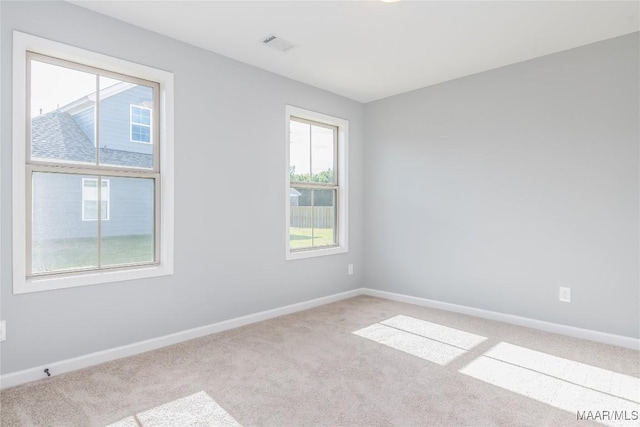 carpeted empty room with visible vents and baseboards