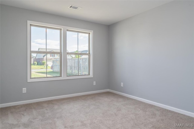 spare room featuring carpet, visible vents, and baseboards