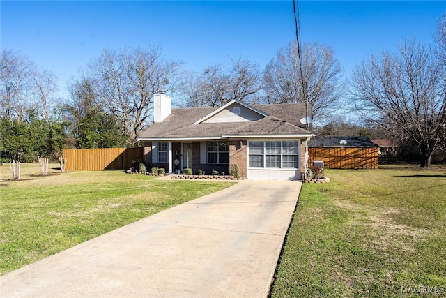 view of front of property with a front yard, brick siding, fence, and a chimney