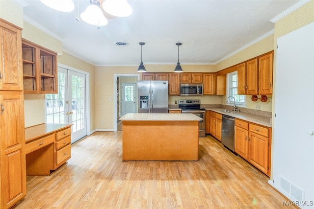 kitchen with a kitchen island, stainless steel appliances, french doors, light wood-type flooring, and a sink