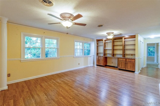 interior space featuring ornate columns, visible vents, and light wood finished floors