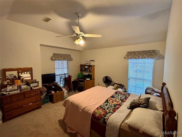 bedroom with a ceiling fan, visible vents, vaulted ceiling, and carpet flooring