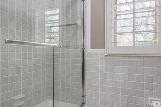 bathroom with bath / shower combo with glass door