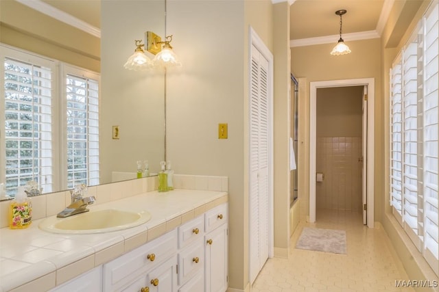 full bathroom featuring a shower with door, crown molding, and vanity