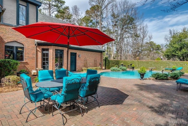 view of patio with outdoor dining space and a fenced in pool