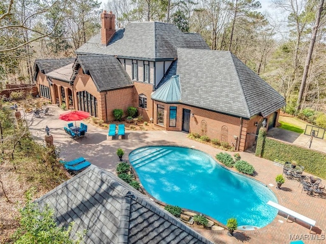 outdoor pool with a patio area and fence