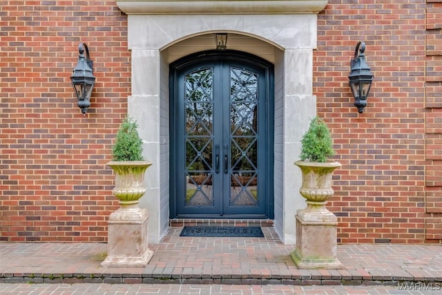 entrance to property featuring french doors and brick siding