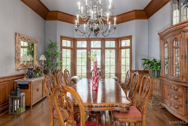 dining room featuring ornamental molding, a chandelier, a wainscoted wall, and wood finished floors