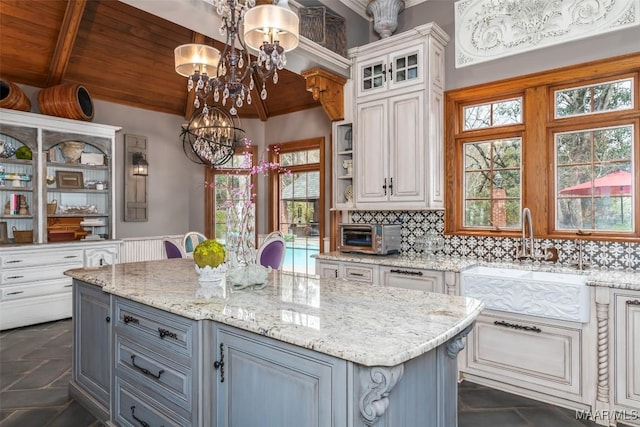 kitchen with wooden ceiling, a sink, gray cabinets, tasteful backsplash, and an inviting chandelier