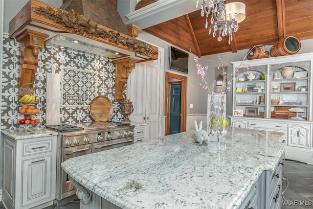 kitchen featuring lofted ceiling, wooden ceiling, light stone countertops, a chandelier, and high end stove