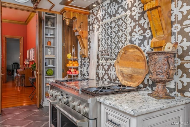 interior details featuring double oven range, light stone counters, and crown molding